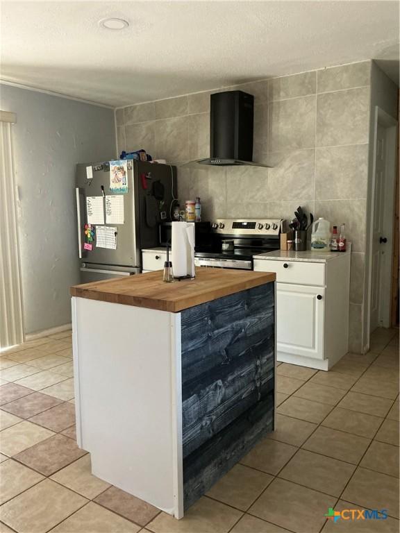 1403 Little St, Copperas Cove, TX 76522 - kitchen with appliances with stainless steel finishes, wall chimney exhaust hood, wooden counters, and light tile patterned floors