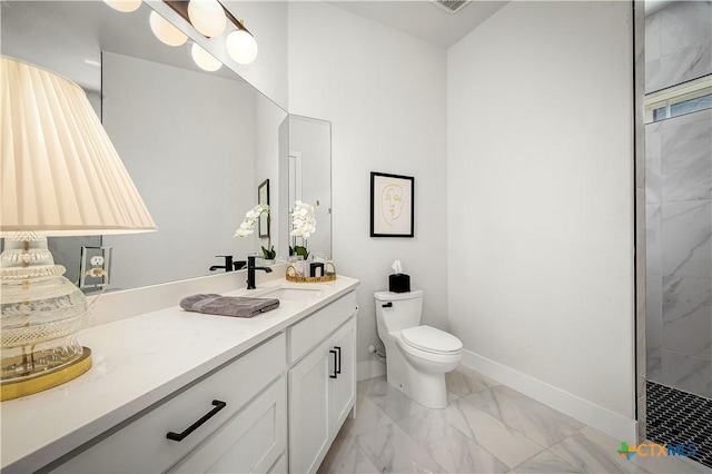 bathroom featuring marble finish floor, toilet, a tile shower, vanity, and baseboards