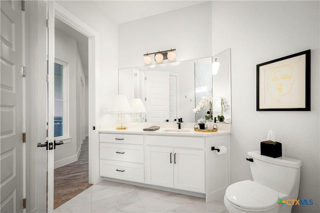 bathroom featuring marble finish floor, vanity, and toilet