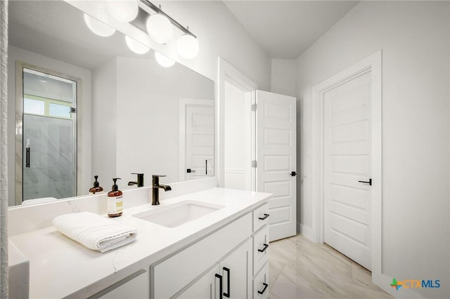 bathroom with marble finish floor, a shower with door, and vanity