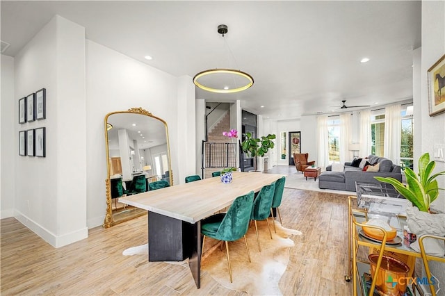 dining area featuring recessed lighting, baseboards, light wood finished floors, and stairs