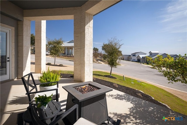 view of patio / terrace featuring an outdoor fire pit and a residential view