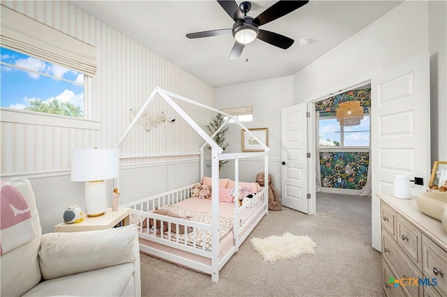 bedroom with light carpet, wallpapered walls, and multiple windows