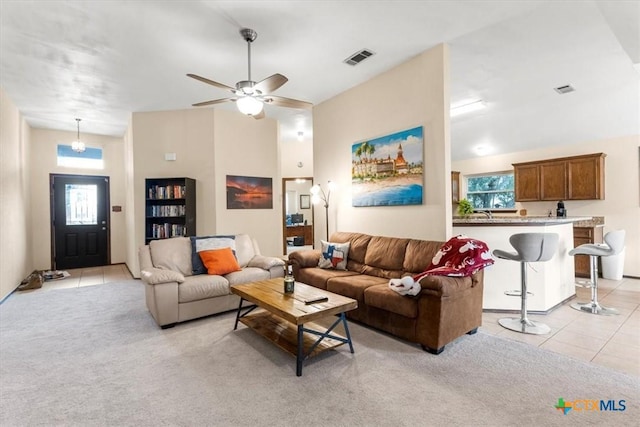 living room featuring ceiling fan, light colored carpet, plenty of natural light, and high vaulted ceiling