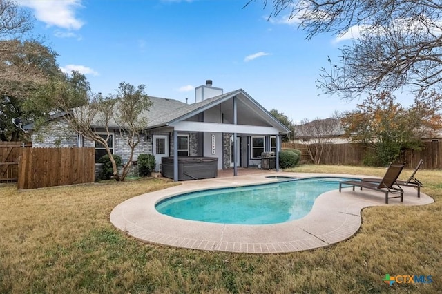 view of swimming pool with a yard, a hot tub, and a patio