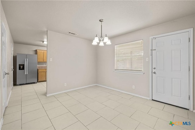 3206 Ida Dr, Killeen, TX 76549 - unfurnished dining area featuring a chandelier, light tile patterned flooring, and a textured ceiling