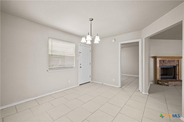 3206 Ida Dr, Killeen, TX 76549 - unfurnished dining area with a chandelier, a brick fireplace, light tile patterned floors, and a textured ceiling