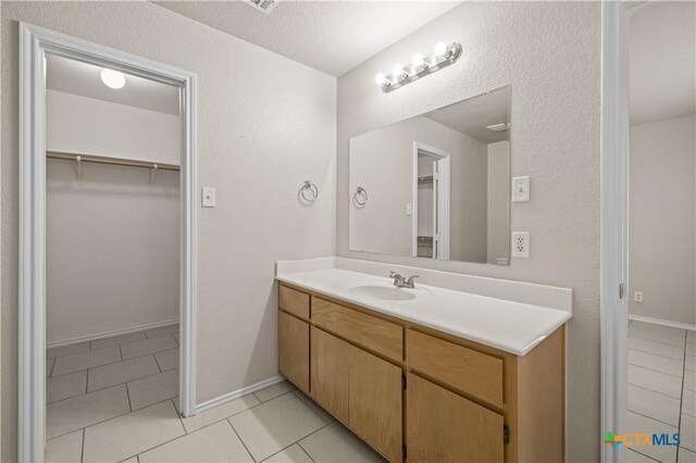 3206 Ida Dr, Killeen, TX 76549 - bathroom with vanity, a spacious closet, and tile patterned floors