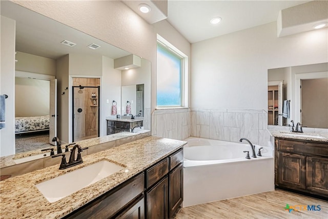 8508 Mount Nebo Cir, Belton, TX 76513 - ensuite bathroom with a bath, wood finished floors, a stall shower, and two vanities