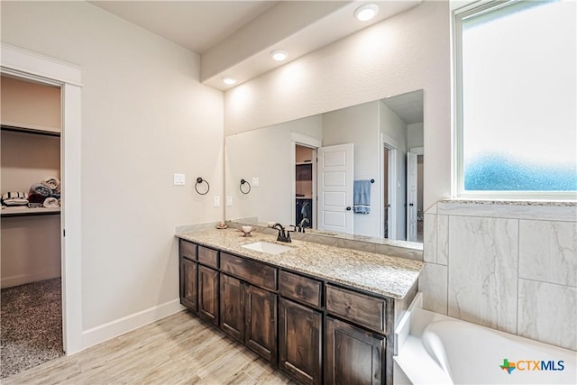 8508 Mount Nebo Cir, Belton, TX 76513 - bathroom featuring a walk in closet, vanity, a bath, baseboards, and wood finished floors