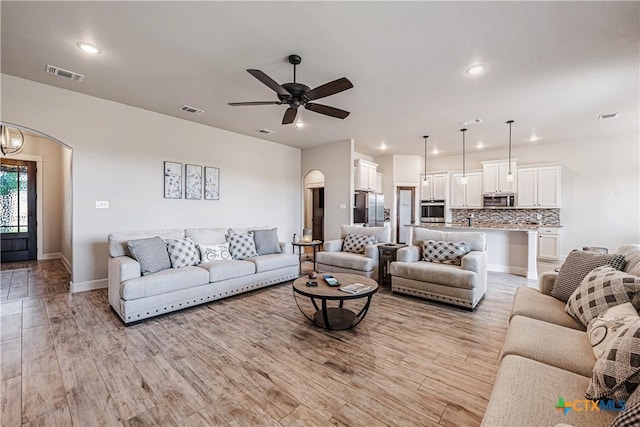 8508 Mount Nebo Cir, Belton, TX 76513 - living room featuring light wood-style floors, ceiling fan, recessed lighting, baseboards, and arched walkways
