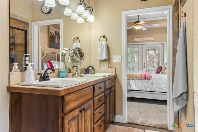 bathroom with a sink, french doors, connected bathroom, and double vanity