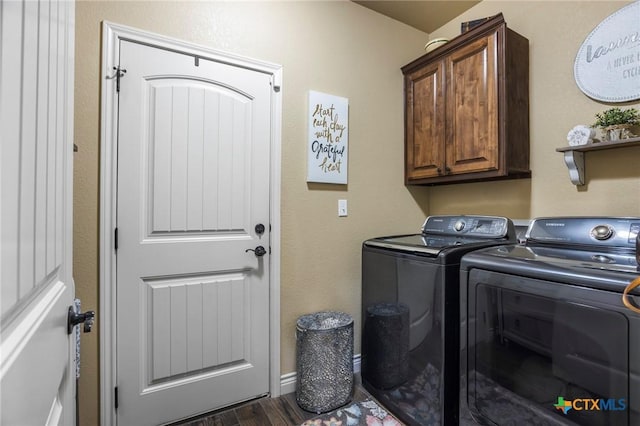 laundry room with cabinet space, dark wood finished floors, and washer and clothes dryer