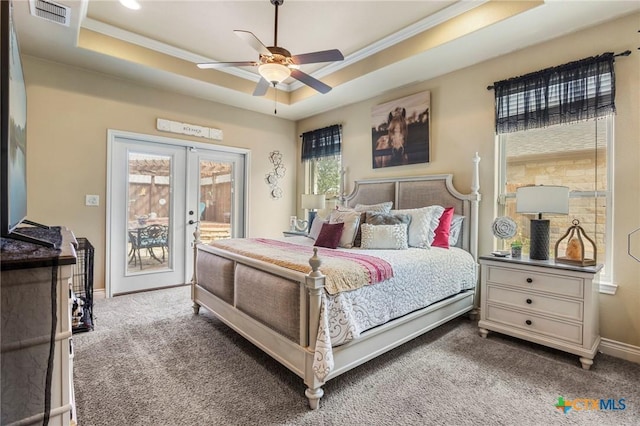 bedroom featuring a tray ceiling, access to outside, french doors, and visible vents