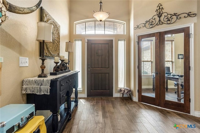 entrance foyer featuring french doors, baseboards, and dark wood-style flooring