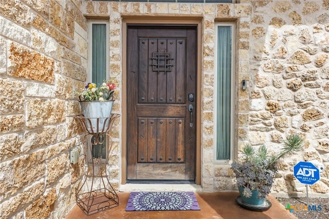 view of exterior entry featuring stone siding