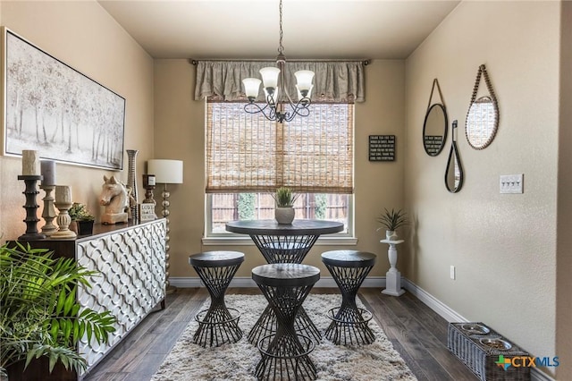 dining area featuring baseboards, a chandelier, and dark wood-style flooring