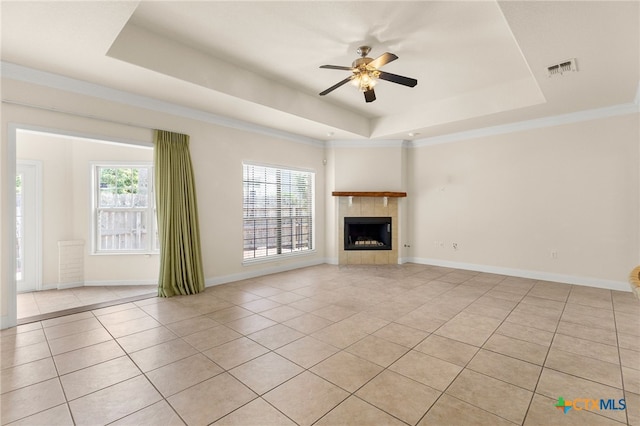 217 Ciela Vis, Seguin, TX 78155 - unfurnished living room featuring a tray ceiling, light tile patterned floors, ceiling fan, and healthy amount of natural light