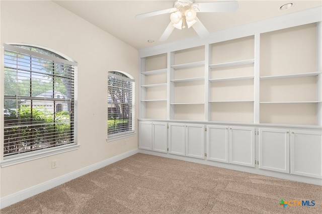 217 Ciela Vis, Seguin, TX 78155 - spare room with light colored carpet, baseboards, a ceiling fan, and built in shelves