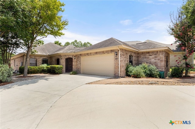 217 Ciela Vis, Seguin, TX 78155 - view of front facade featuring a garage, brick siding, concrete driveway, and a shingled roof