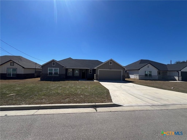 view of front of property with a garage, concrete driveway, and a front yard