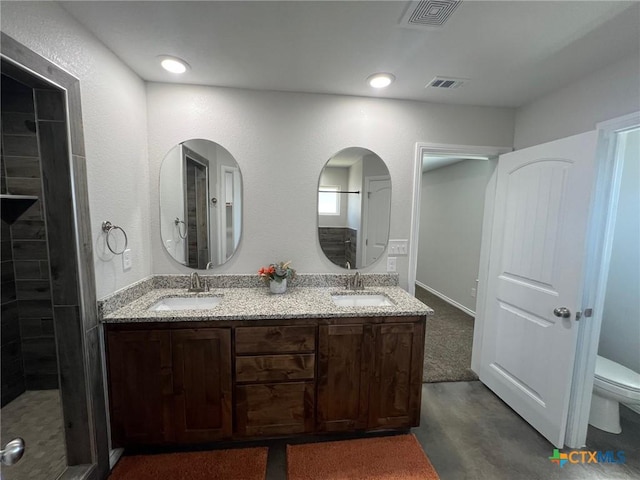 bathroom featuring visible vents, toilet, and a sink