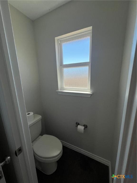 bathroom with toilet and baseboards