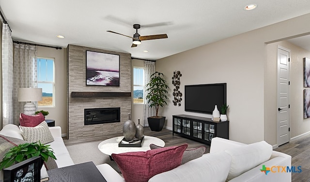 living room featuring ceiling fan, a fireplace, and hardwood / wood-style floors