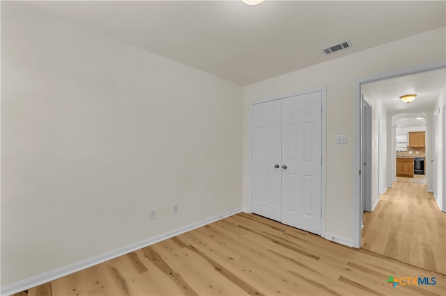 unfurnished bedroom with a closet and light hardwood / wood-style floors