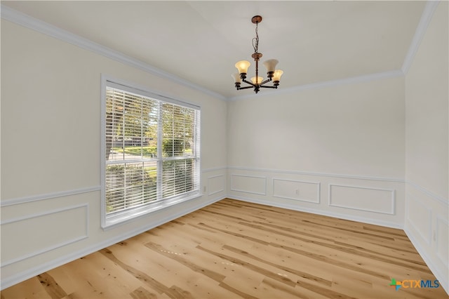 unfurnished room with hardwood / wood-style flooring, a notable chandelier, and ornamental molding