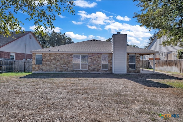 rear view of house featuring a yard