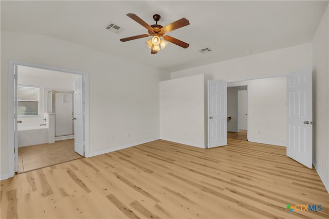 unfurnished bedroom featuring light wood-type flooring, ensuite bath, and ceiling fan