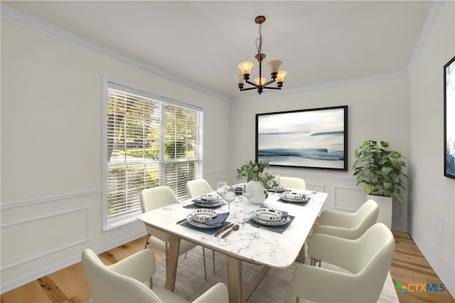 dining room featuring ornamental molding, a notable chandelier, and light wood-type flooring