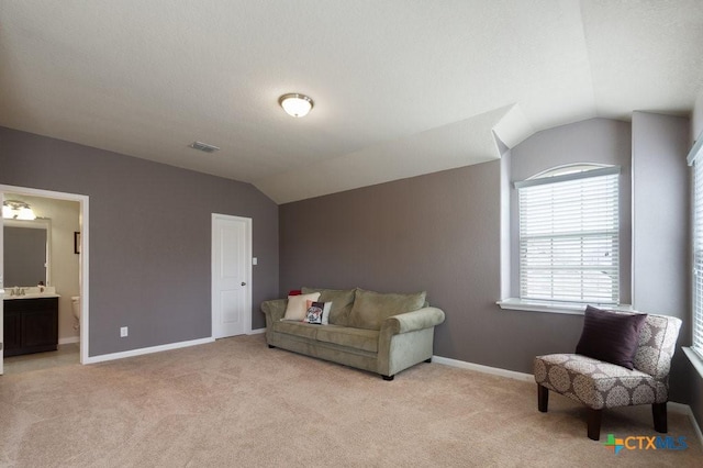 living area featuring light colored carpet and vaulted ceiling