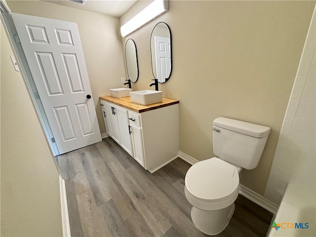 bathroom with vanity, hardwood / wood-style floors, and toilet