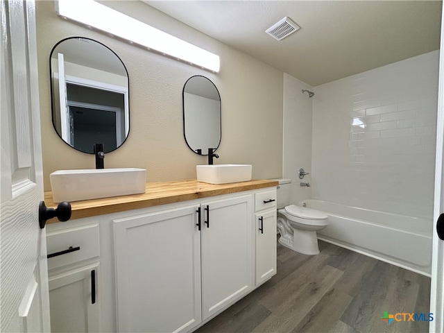 full bathroom with toilet, hardwood / wood-style floors, vanity, and bathing tub / shower combination