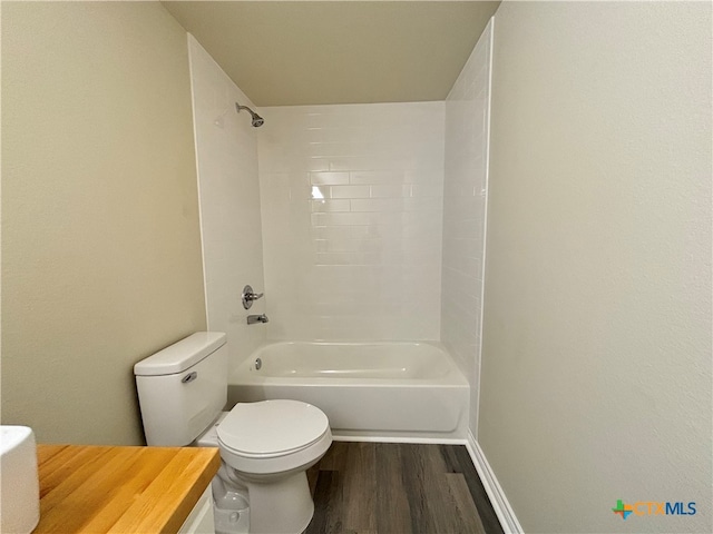 bathroom with hardwood / wood-style floors, tiled shower / bath combo, and toilet