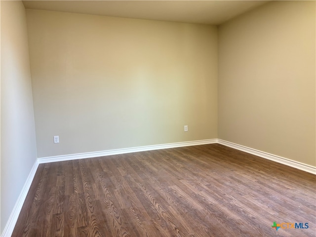 spare room with dark hardwood / wood-style flooring