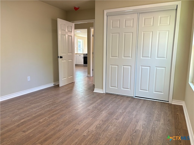 unfurnished bedroom featuring dark hardwood / wood-style flooring and a closet