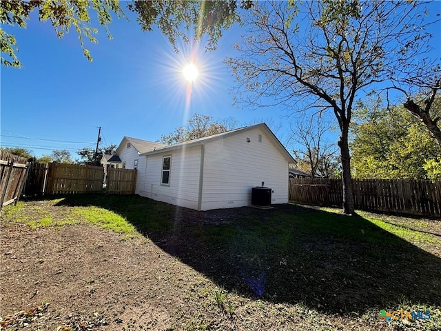 view of property exterior with central AC and a yard