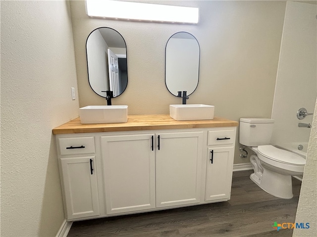 full bathroom featuring hardwood / wood-style floors, vanity,  shower combination, and toilet