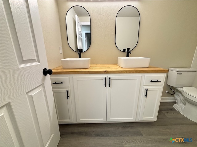 bathroom with vanity, hardwood / wood-style flooring, and toilet