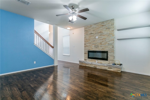 unfurnished living room with dark hardwood / wood-style flooring, ceiling fan, and a fireplace