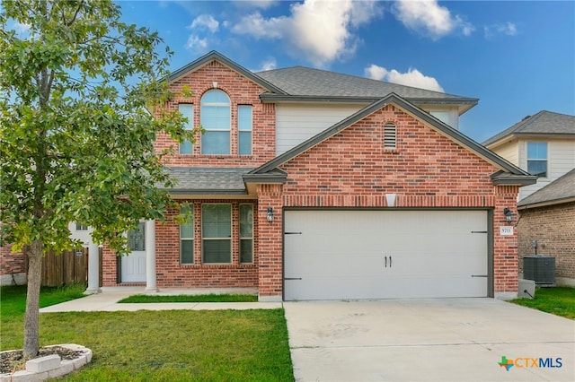 front of property featuring central AC, a front lawn, and a garage