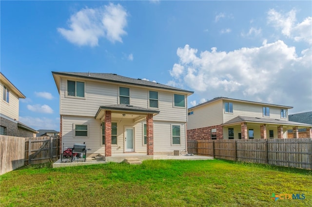 rear view of property with a yard and a patio area