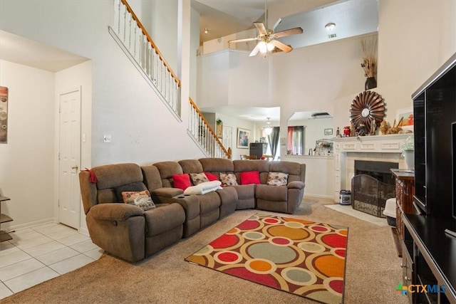 5407 Whistle Stop Dr, Temple, TX 76502 - carpeted living room with stairway, a ceiling fan, a tiled fireplace, a high ceiling, and tile patterned flooring