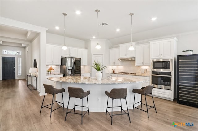 156 High Plains Dr, Georgetown, TX 78628 - kitchen with appliances with stainless steel finishes, beverage cooler, white cabinets, a breakfast bar, and recessed lighting