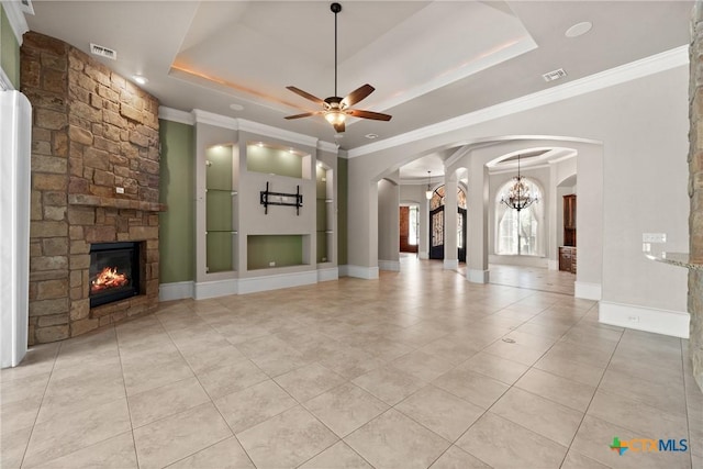12 Sereno Vista Ln, Belton, TX 76513 - unfurnished living room with a stone fireplace, arched walkways, a raised ceiling, crown molding, and light tile patterned floors