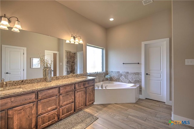 bathroom featuring vanity, wood-type flooring, and shower with separate bathtub