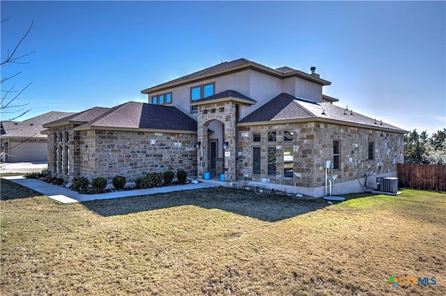 view of front of home with a front yard and central AC unit